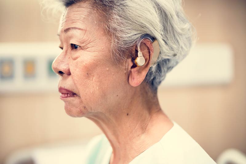 Elderly woman with hearing aid