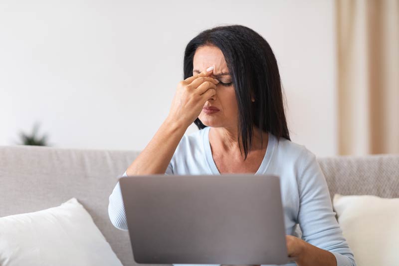 Fatigued mature woman massaging nose