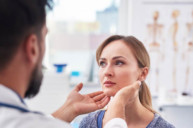 Doctor examines female neck for cancer & masses