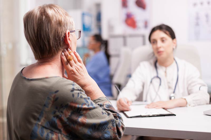 Mature woman holding neck with cancer