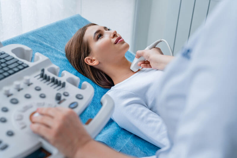 woman getting her neck examined by female doctor