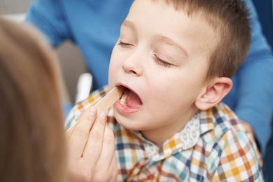 Doctor checking child throat with tongue tie & swallowing disorder