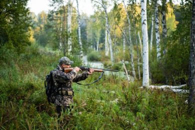 Hunter aiming weapon using ear protection