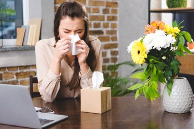 Young woman blowing nose